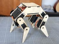 a wooden robot that is on top of a piece of paper with wires attached to it