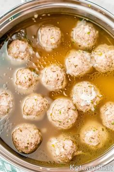 the meatballs are being cooked in the pot with broth and oil on the side