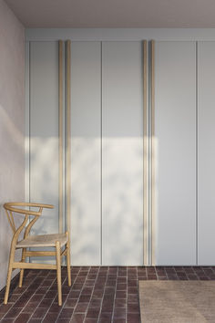 a chair sitting on top of a red brick floor next to a wall with sliding doors