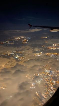 an airplane wing flying over the city lights