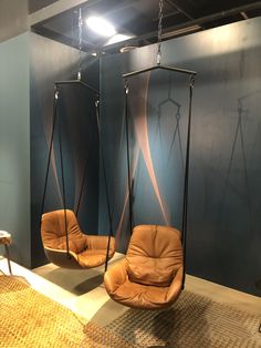 two hanging chairs in the middle of a room with blue walls and brown carpet on the floor