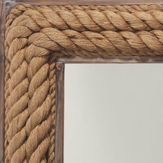 a mirror that is made out of rope and has a wooden frame with a knot on it