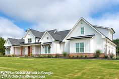 a large white house sitting on top of a lush green field