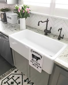 a white kitchen sink sitting on top of a counter next to a dishwasher