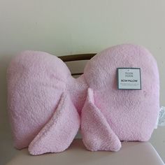 a pink bow pillow sitting on top of a chair