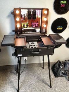 a vanity table with lights on it in front of a mirror and some other items