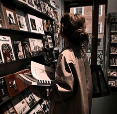 a woman standing in front of a book shelf filled with books