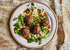 a white plate topped with meatballs and salad