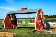 a red barn with a green slide in it