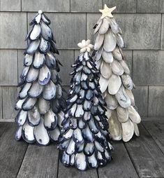 three ceramic christmas trees sitting on top of a wooden table