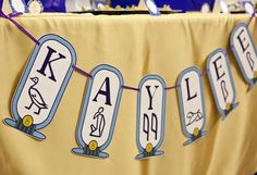 a banner with letters and numbers on it hanging from a table at a children's birthday party