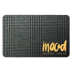 a black and white checkered door mat with the word macd in gold on it