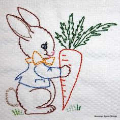 a bunny holding a carrot on top of a towel