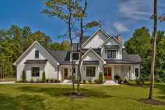 a large white house with trees in the front yard