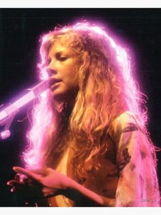 a woman with long hair holding a microphone