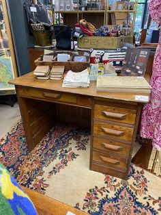 an old desk with lots of books on it in a room filled with other items