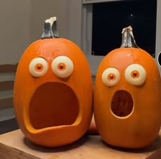 two pumpkins with googly eyes are sitting on a table