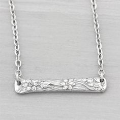 a silver necklace with flowers on it