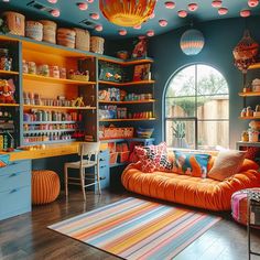 a brightly colored living room with lots of shelves and colorful decor on the walls, along with an orange couch