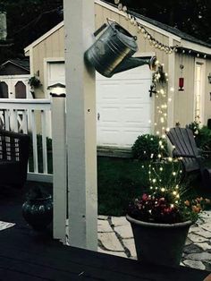 a potted plant with lights hanging from it's side in front of a house