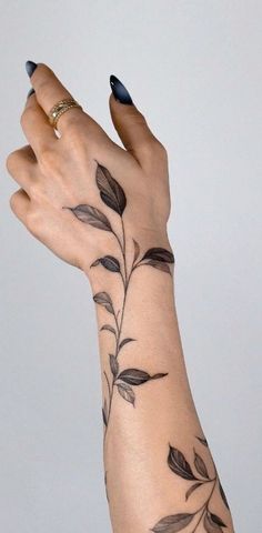 a woman's arm with leaves on it