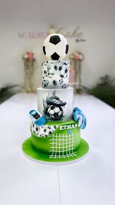 a three tiered cake decorated with soccer balls and other sports related items on it