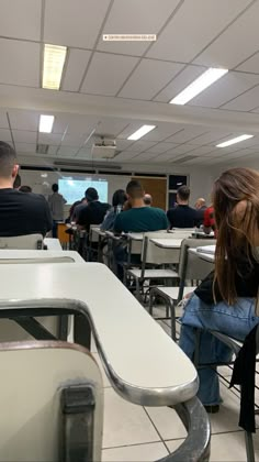 people are sitting at desks in a classroom