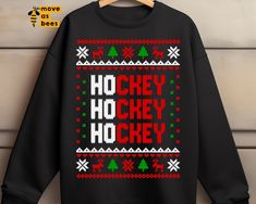 a black sweatshirt with the words ho hey hockey in red, green and white snowflakes