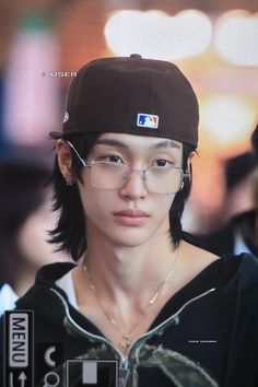 a young man wearing glasses and a baseball cap