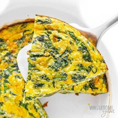 an omelet with spinach and cheese in a white casserole dish