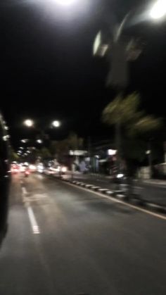 a blurry photo of cars driving down the street at night