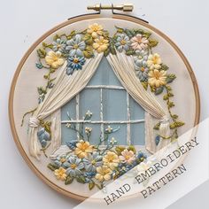 a hand embroidery pattern with flowers and curtains on the window sill, in front of a white background