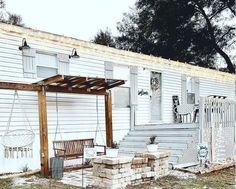 a small white house with a porch and swing