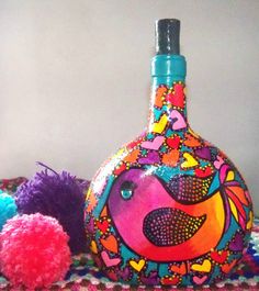 there is a colorful bottle with a bird on it next to some balls and yarn