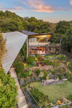 an aerial view of a house in the middle of trees and grass with stairs leading up to it