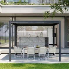 an outdoor dining area with white chairs and marble top table in front of a modern house