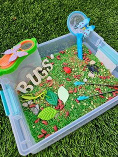 a plastic container filled with grass and toys