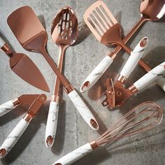 the kitchen utensils are all made out of marble and gold colored metal spoons