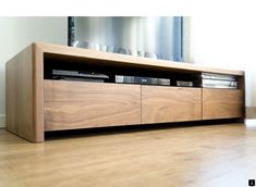 a wooden entertainment center sitting on top of a hard wood floor