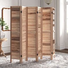 the room divider is made out of wood and has four panels on each side