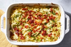 a casserole dish with bacon, cheese and green onions