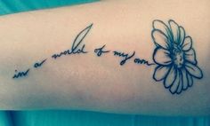 a woman's arm with a flower and the words i am a world to my own written on it