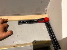 a person measuring the width of a piece of wood