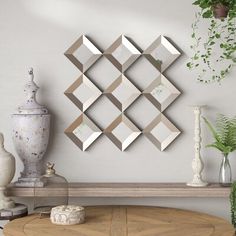 a table with some vases on top of it next to a wall mounted mirror