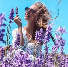 a woman sitting in a field of purple flowers