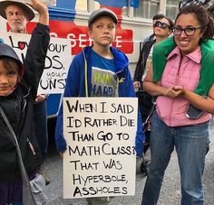 a group of people standing around each other with signs on their backs and one holding a sign that says, when i said it rather die than go to math class