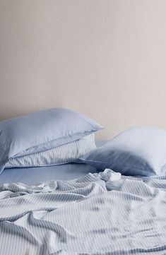 a bed with blue sheets and pillows on it