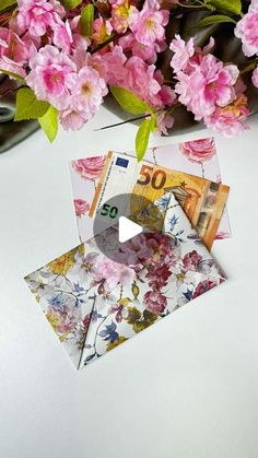 some pink flowers are on a white table and there is a cd in the middle