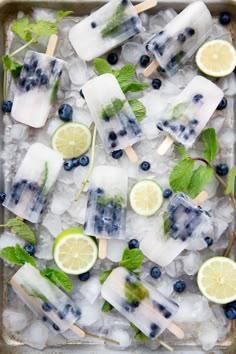 popsicles with blueberries, limes and mint on top of ice cubes