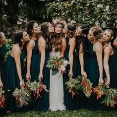 a group of women standing next to each other in front of trees and flowers on their heads